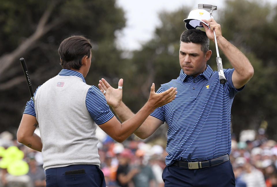 U.S. team player Rickie Fowler, left, and playing partner Gary Woodland shake hands after their foursomes match during the President's Cup golf tournament at Royal Melbourne Golf Club in Melbourne, Friday, Dec. 13, 2019. (AP Photo/Andy Brownbill)