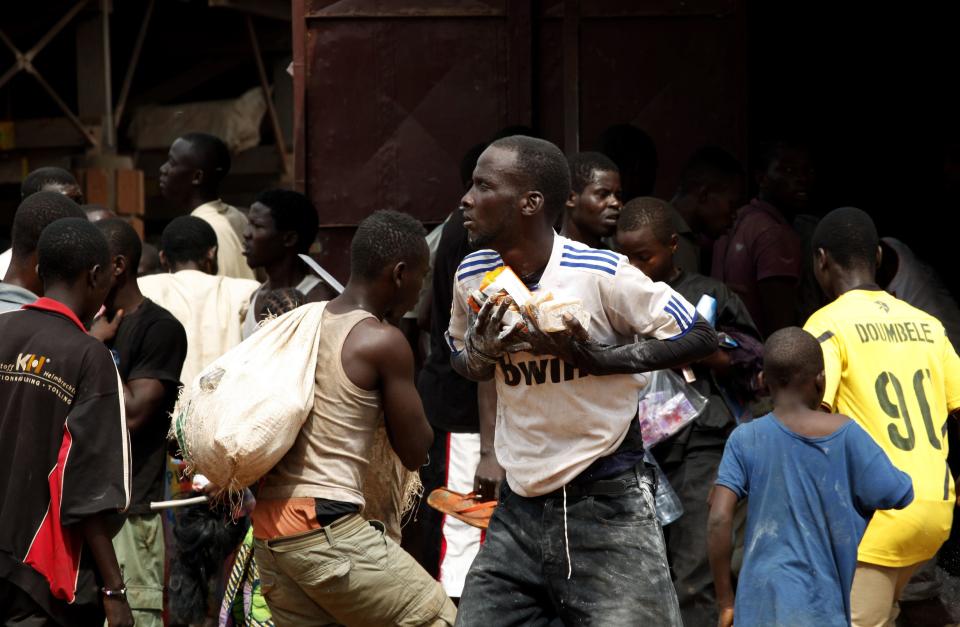People are seen looting in Bangui, the capital of Central African Republic, December 10, 2013. The French army said it has restored some stability in the capital of Central African Republic after battling gunmen on Monday in an operation to disarm rival Muslim and Christian fighters responsible for killing hundreds since last week. REUTERS/Emmanuel Braun (CENTRAL AFRICAN REPUBLIC - Tags: CIVIL UNREST POLITICS RELIGION CONFLICT)