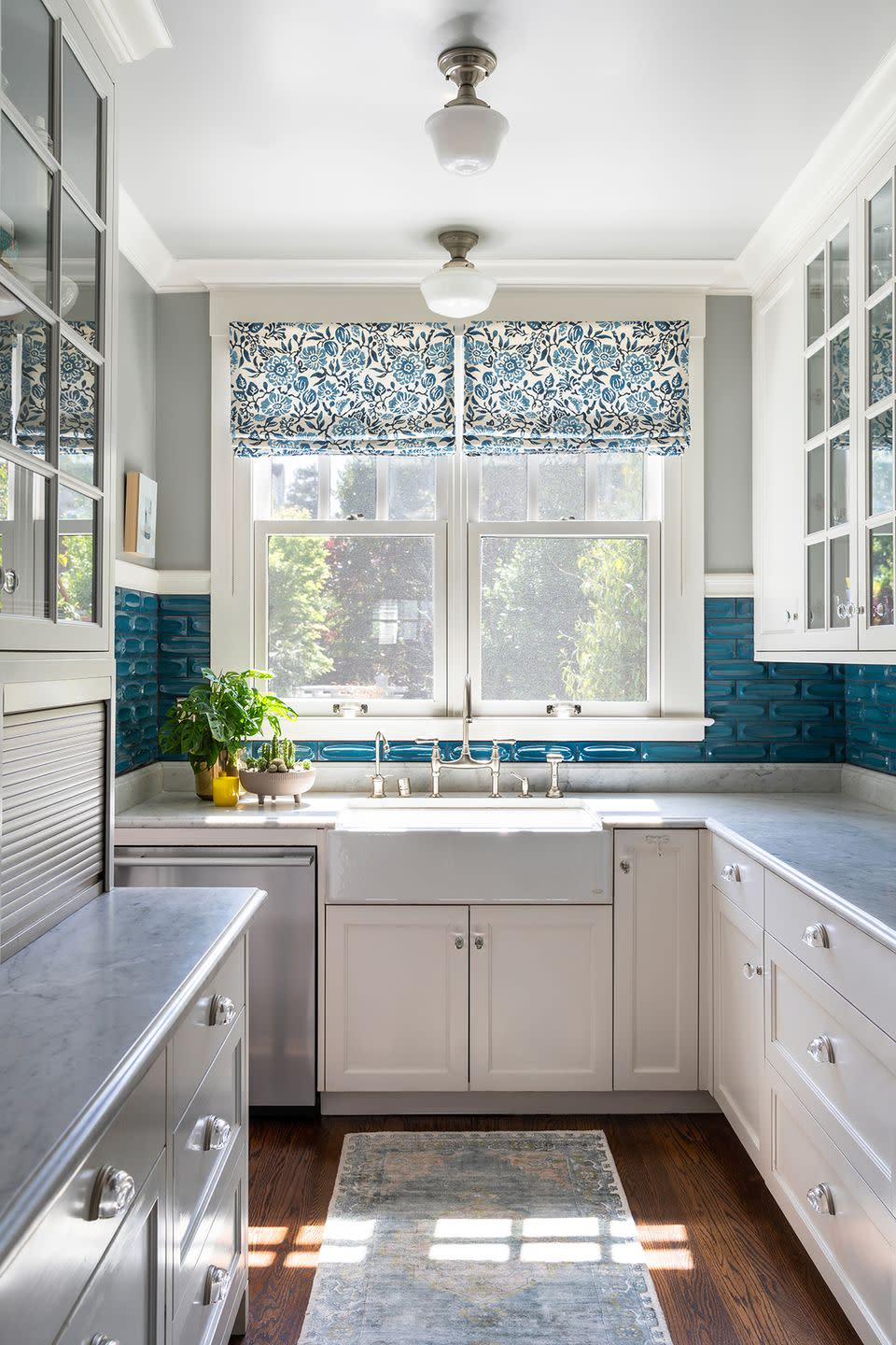 a kitchen with a large window and blue accents