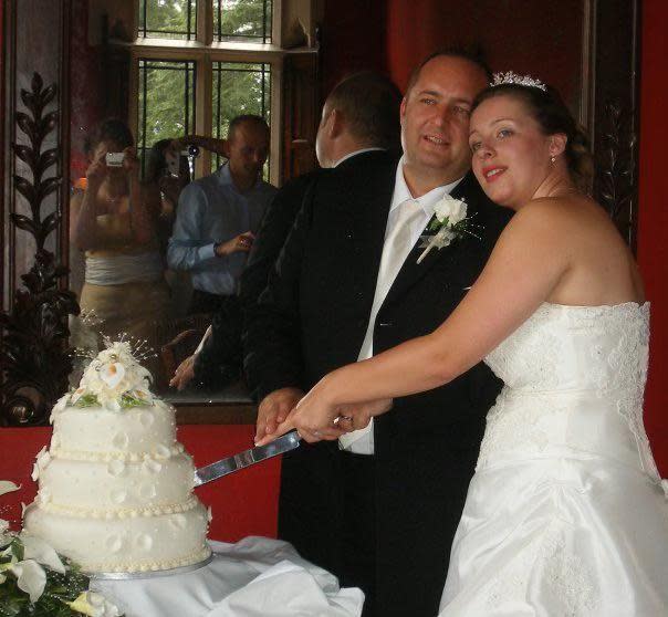 Wedding cake being cut by couple