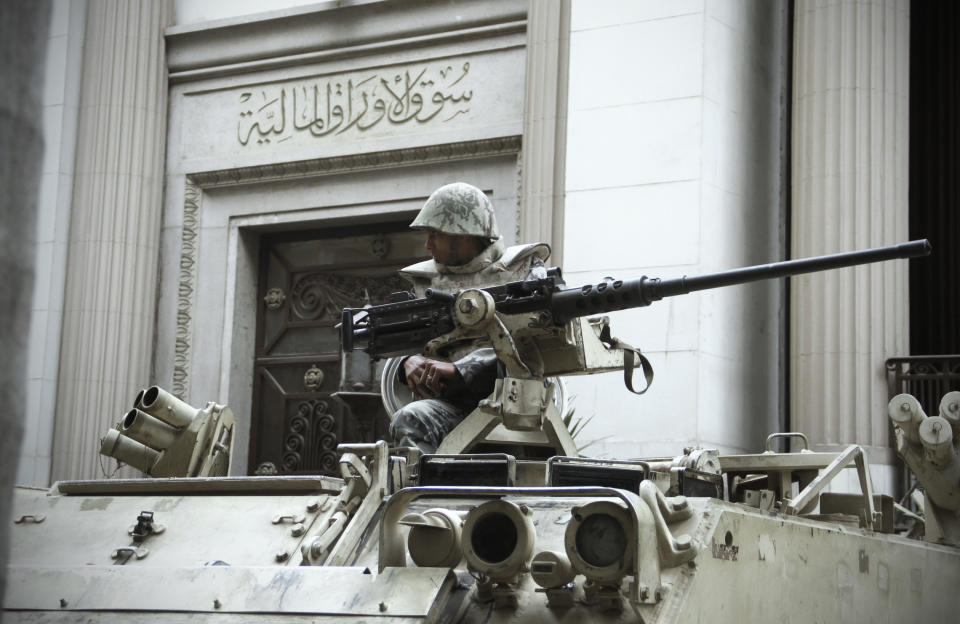 FILE - In this Sunday, Feb. 20, 2011 file photo, An Egyptian army soldier stands alert in front of Cairo's stock market in Cairo, Egypt. The Egyptian military receives around $1 billion a year in U.S. aid, one of the largest recipients. But its budget is largely unknown. Under Mubarak and previous leaders, the budget was discussed in a secret panel in parliament, dominated by ruling party officials and loyalists. (AP Photo/Ahmed Ali, File)
