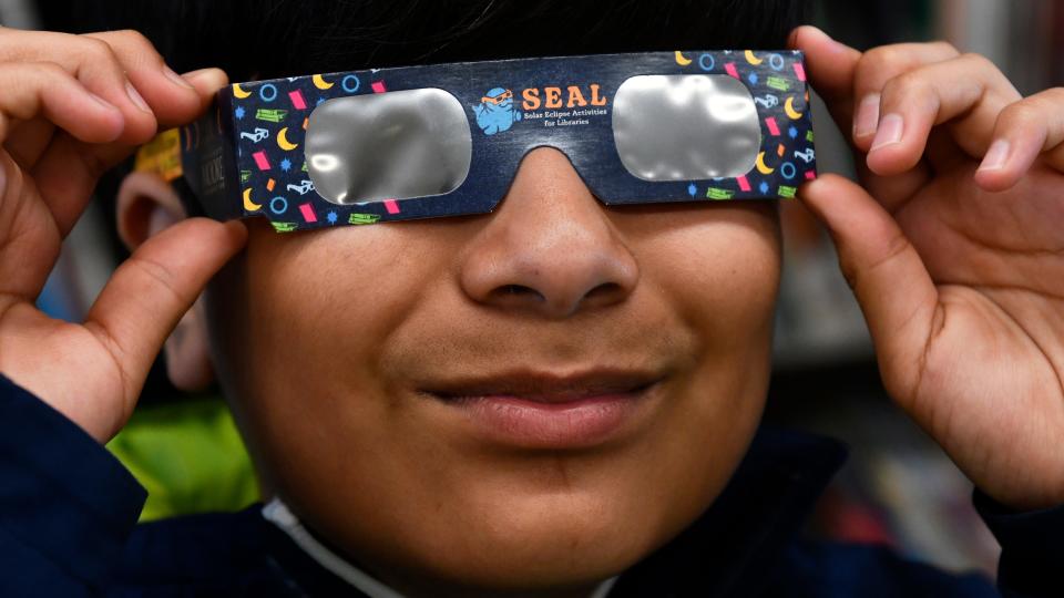 David Martinez, 12 of Bridgeton, tries on solar eclipse glasses provided before supplies ran out at the Cumberland County Library in Bridgeton, NJ on Tuesday, April 2, 2024.