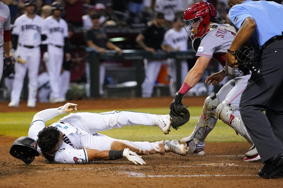 Arizona Diamondbacks' Gabriel Moreno is thrown out at the plate trying to score on a base hit by Jace Peterson as Cincinnati Reds' catcher Tyler Stephenson makes the tag during the seventh inning of a baseball game, Thursday, Aug. 24, 2023, in Phoenix. (AP Photo/Matt York)