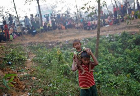 A Rohingya refugee boy carries his brother as he arrives to collect humanitarian aid at Kutupalong refugee camp near Cox's Bazar, Bangladesh October 24, 2017. REUTERS/Adnan Abidi