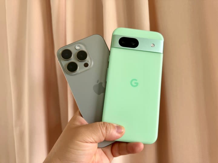 iPhone 15 Pro (left) and Google Pixel 8a in hand.
