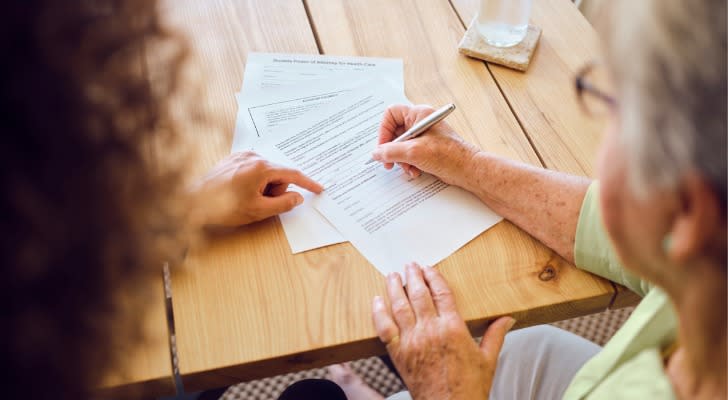 A woman signs paperwork establishing a trust for her family.