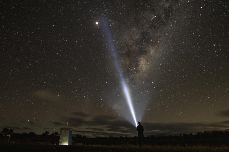 RYLSTONE, AUSTRALIA - MAY 26: A man looks towards the supermoon and the milky way on May 26, 2021 in Rylstone, Australia. It is the first total lunar eclipse in more than two years, which coincides with a supermoon.  A super moon is a name given to a full (or new) moon that occurs when the moon is in perigee - or closest to the earth - and it is the moon's proximity to earth that results in its brighter and bigger appearance. (Photo by Mark Evans/Getty Images)
