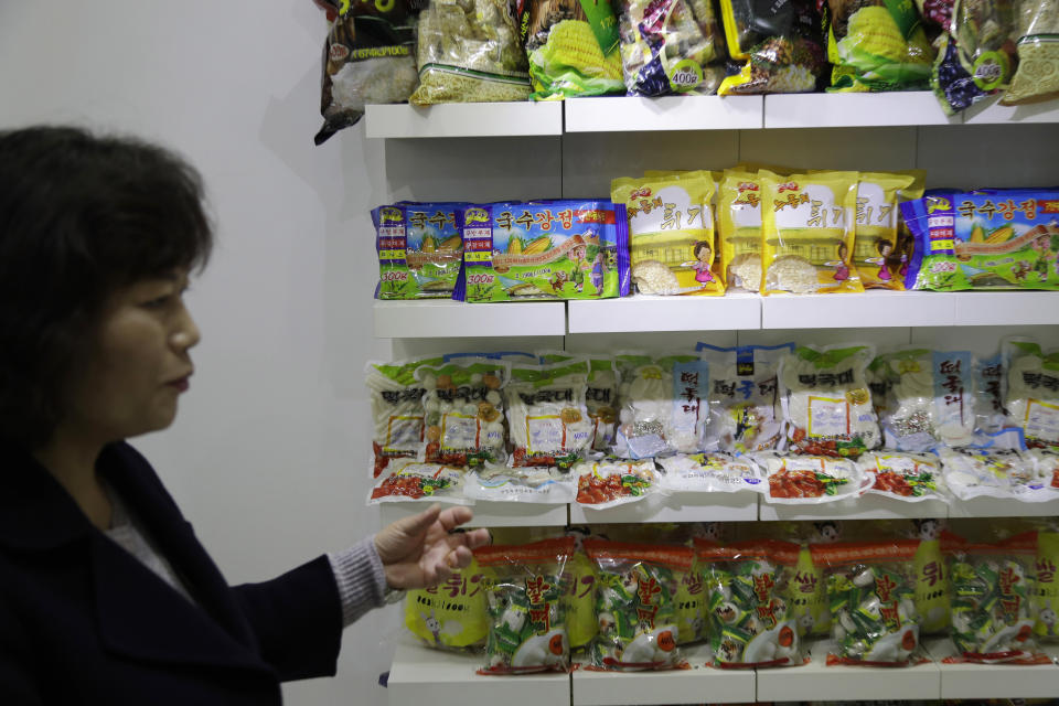 In this March 13, 2019, photo, a guide shows samples of food produced at Kumkhop Trading Co. displayed in its show room Pyongyang, North Korea. North Korean factories are filling city store shelves with ever better and fancier snack foods and sugary drinks, while government officials and international aid organizations warn the nation could be on the verge of a major food crisis. (AP Photo/Dita Alangkara)