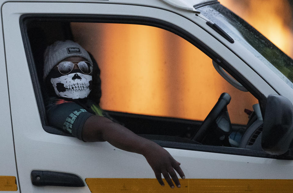 Un conductor de un minibús, portando una mascarilla, recorre el barrio de Kwa-Thema, en el este de Johannesburgo, Sudáfrica, el martes 17 de marzo de 2020. (AP Foto/Themba Hadebe)