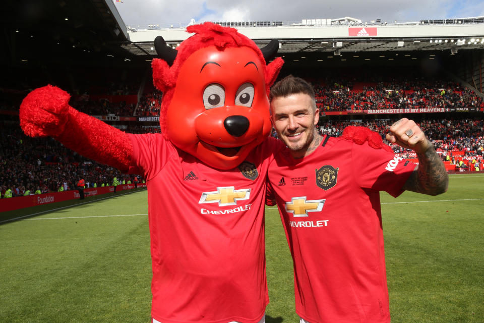 David Beckham celebrates with Manchester United mascot Fred the Red at the end of the 20 Years Treble Reunion match between Manchester United '99 Legends and FC Bayern Legends at Old Trafford in 2019. 