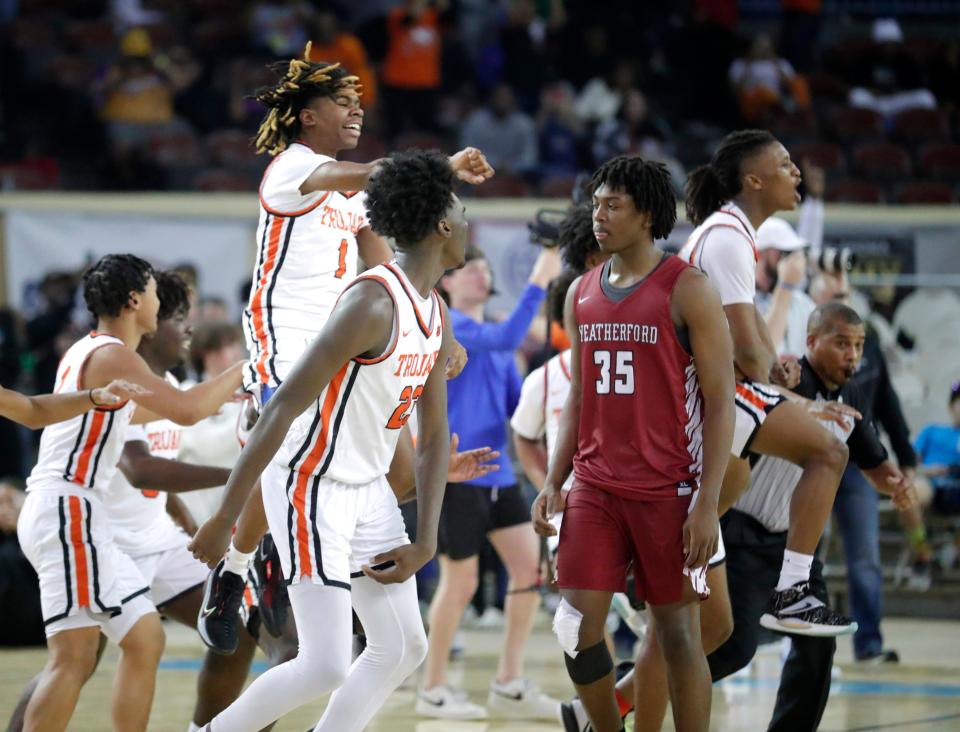 Douglass celebrates winning the Class 4A state championship as Weatherford's CJ Nickson (35) walks off the court at State Fair Arena on March 11.