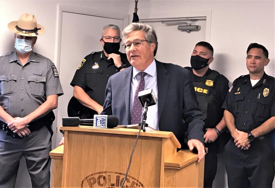 Chemung County District Attorney Weeden Wetmore, foreground, is joined by various law enforcement officials Monday, Oct. 4, 2021, to discuss details of the investigation into the torture and murder of a New York City man in Elmira.