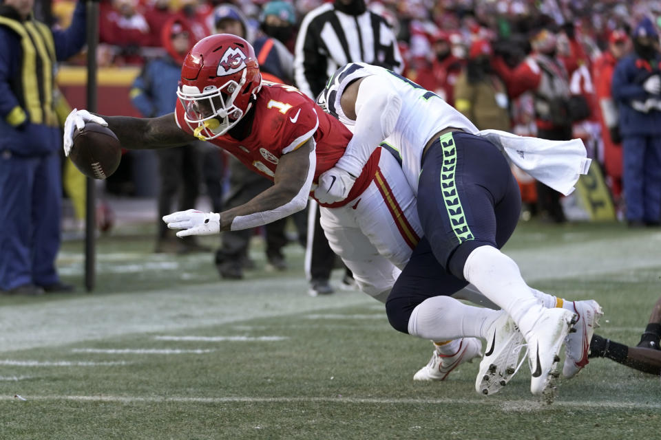 Kansas City Chiefs running back Jerick McKinnon (1) scores past Seattle Seahawks linebacker Jordyn Brooks during the first half of an NFL football game Saturday, Dec. 24, 2022, in Kansas City, Mo. (AP Photo/Ed Zurga)