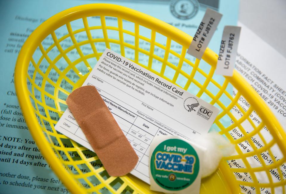 A basket containing a COVID-19 vaccination card is readied for people receiving the Pfizer vaccine at the Sangamon County Department of Public Health Vaccination Site in Springfield, Ill., on Dec. 9, 2021.