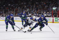 St. Louis Blues' Vladimir Tarasenko (91), of Russia, skates with the puck between Vancouver Canucks' Elias Pettersson (40), of Sweden, and Quinn Hughes (43) during the third period of an NHL hockey game in Vancouver, British Columbia, Sunday, Jan. 23, 2022. (Darryl Dyck/The Canadian Press via AP)