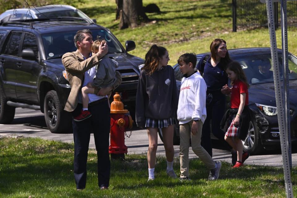 A family leaves with their children from a reunification site in Nashville, Tenn., Monday, March 27, 2023. Officials say several children were killed in a shooting at Covenant School in Nashville. The suspect is dead after a confrontation with police. (AP Photo/John Amis)