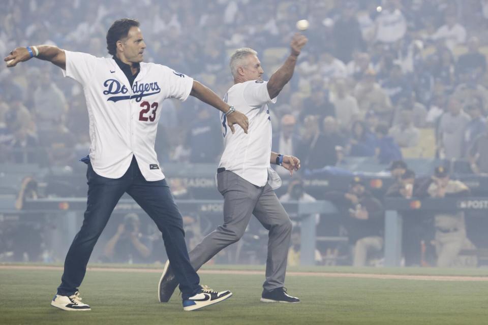 Eric Karros, left, and Steve Sax throw out the ceremonial first pitch before Game 1 of the 2022 NLDS at Dodger Stadium.