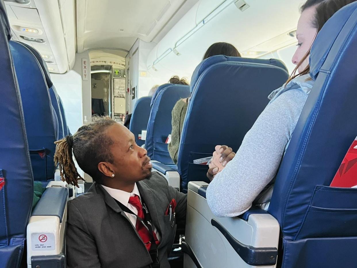 Delta flight attendant Floyd Dean-Shannon consoles a passenger on a flight from Charlotte, North Carolina to NYC on January 14, 2023.