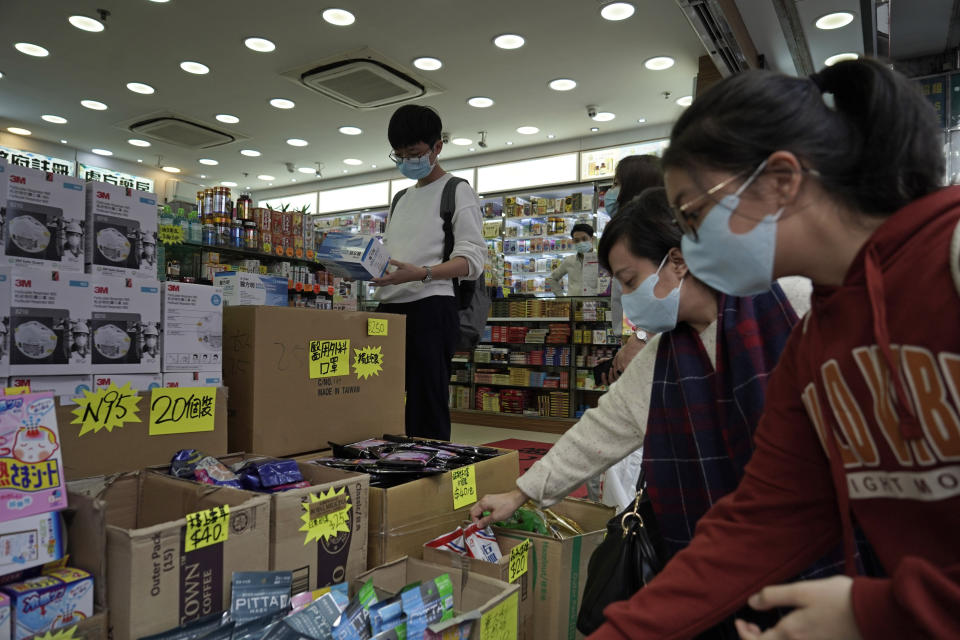 Customers purchase protective face masks at a pharmacy in Hong Kong, Thursday, Jan. 23, 2020. China closed off a city of more than 11 million people Thursday, halting transportation and warning against public gatherings, to try to stop the spread of a deadly new virus that has sickened hundreds and spread to other cities and countries in the Lunar New Year travel rush. (AP Photo/Kin Cheung)