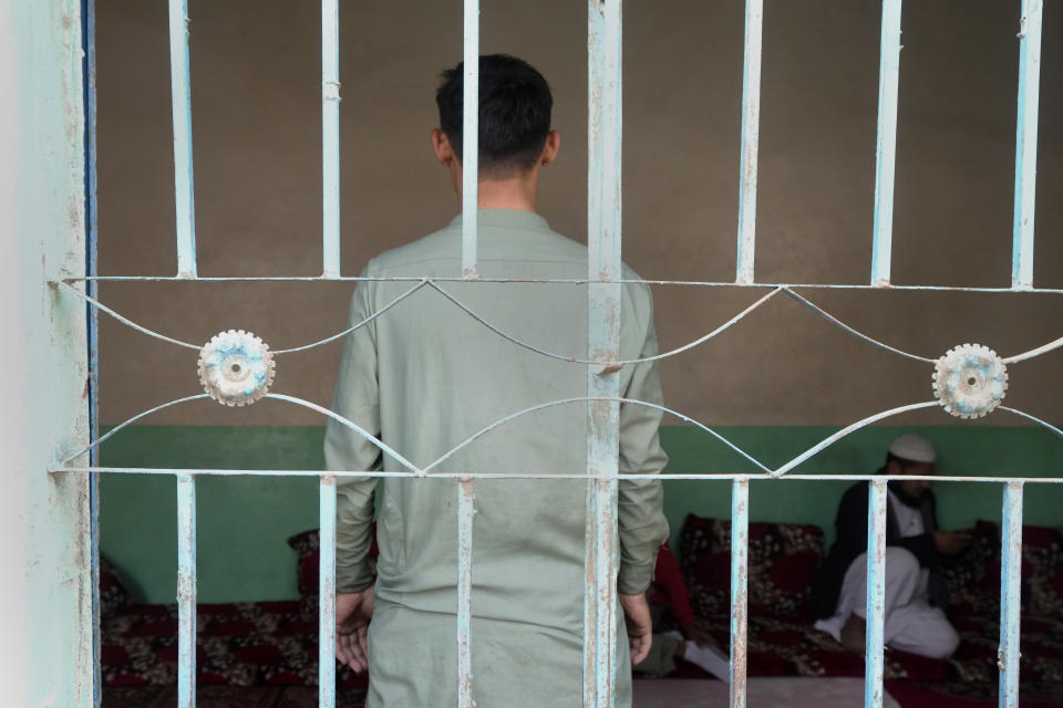 An 18-year-old Afghan boy, who asked not to use his name and not to show his face fearing his identity could lead to his capture again, pose for photograph behind a window during an interview with The Associated Press, in Karachi, Pakistan, Friday, Jan. 26, 2024. Born and raised in Pakistan to parents who fled neighboring Afghanistan half a century ago, an 18-year-old found himself at the mercy of police in Karachi who took his cash, phone and motorbike, and sent him to a deportation center. (AP Photo/Fareed Khan)