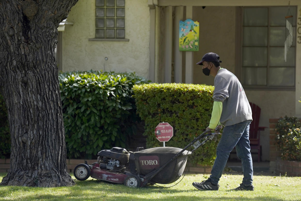 A gardener mows a lawn at a home in Sacramento, Calif. in 2021. (Rich Pedroncelli/AP) 

