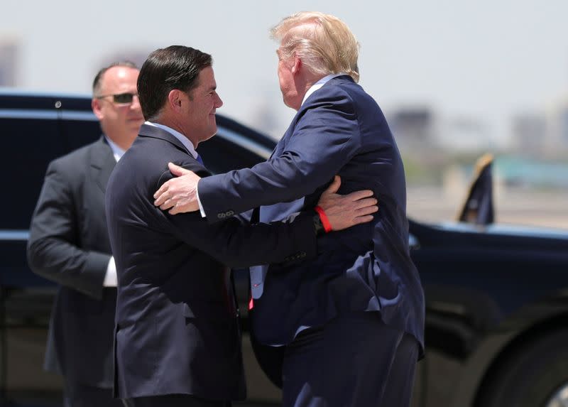 U.S. President Trump hugs Arizona Governor Doug Ducey as he arrives in Phoenix, Arizona