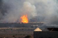 Flames and smoke billow from the site of an explosion that hit an arms depot in Yemen's second city of Aden on March 28, 2015