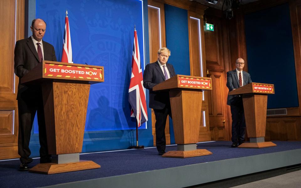 Britain's Prime Minister Boris Johnson (C), Britain's Chief Medical Officer for England Chris Whitty (L) and Britain's Chief Scientific Adviser Patrick Vallance host a virtual press conference to update the nation on the status of the Covid-19 pandemic, in the Downing Street briefing room in central London on January 4, 2022. - British hospitals have switched to a 