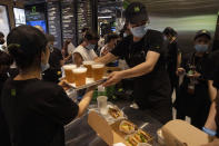 Workers serve beer at the opening of the first Beijing outlet for Shake Shack in Beijing on Wednesday, Aug. 12, 2020. The U.S. headquartered burger chain is opening its first Beijing restaurant at a time when China and the U.S. are at loggerheads over a long list of issues. (AP Photo/Ng Han Guan)
