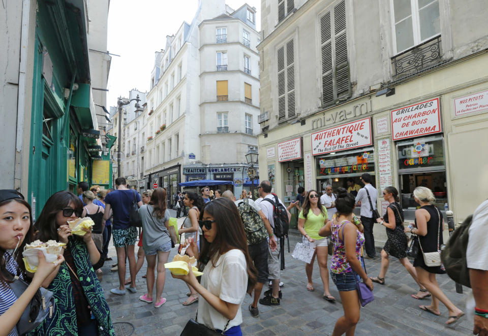 Tourists walk in the streets of the Jewish quarter around " Le Marais' of Paris, Wednesday, July 17, 2013. Many shops in this former Jewish quarter (turned Paris’ gay center, turned trendy shopping hot spot) follow tradition and stay closed on Saturday to open on Sunday. While the rest of Paris can feel sleepy, the Marais positively buzzes on Sundays. (AP Photo/Jacques Brinon)