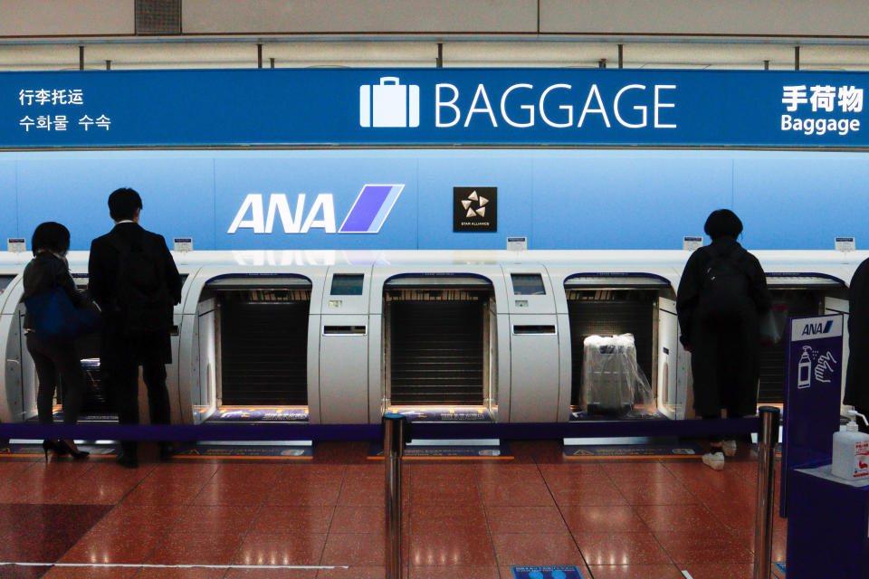 TOKYO, JAPAN - 2021/03/11: Passengers use automatic baggage check-in machines as All Nippon Airways (ANA) launches the baggage machine with newly developed touchless screen which has optical sensors on its frame of the screen at the Haneda airport in Tokyo.
 All Nippon Airways Co. said it will suspend services on 16 international flight routes from late March due to falling travel demand amid the coronavirus pandemic. (Photo by James Matsumoto/SOPA Images/LightRocket via Getty Images)