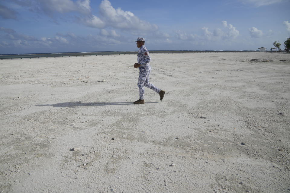 A Philippine coast guard runs at the Philippine-occupied Thitu island, locally called Pag-asa island, on Friday, Dec. 1, 2023 at the disputed South China Sea. The Philippine coast guard inaugurated a new monitoring base Friday on a remote island occupied by Filipino forces in the disputed South China Sea as Manila ramps up efforts to counter China's increasingly aggressive actions in the strategic waterway. (AP Photo/Aaron Favila)