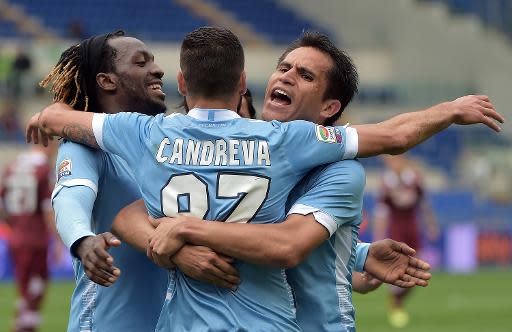 El belga Luis Pedro Cavanda (I) y el argentino Cristian Ledesma (D) felicitan a su compañero Antonio Candreva (C) por su gol con la Lazio en el empate a tres goles ante el Torino, el 19 de abril de 2014, en Roma (AFP | GABRIEL BOUYS)