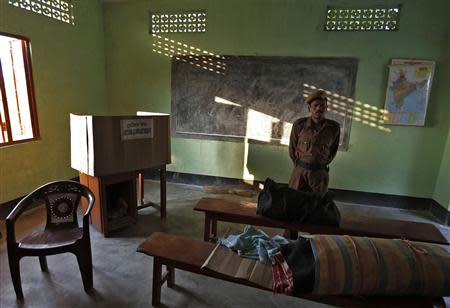 A policeman stands guard over an Electronic Voting Machine (EVM) at a polling booth ahead of the general elections in Majuli, a large river island in the Brahmaputra river, Jorhat district, in the northeastern Indian state of Assam April 6, 2014. REUTERS/Adnan Abidi