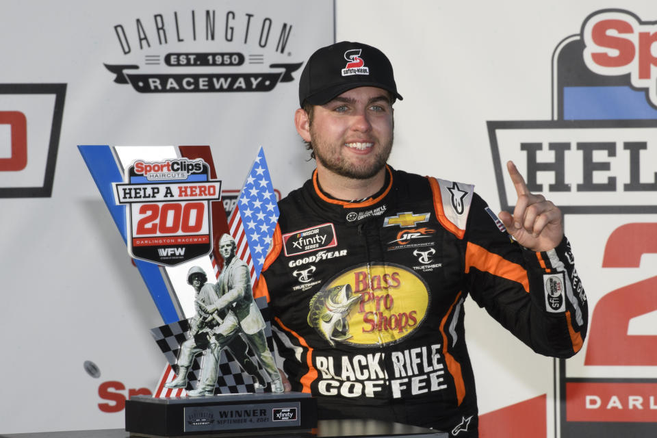 Noah Gragson stands with the trophy after winning a NASCAR Xfinity Series auto race Saturday, Sept. 4, 2021, in Darlington, S.C. (AP Photo/John Amis)