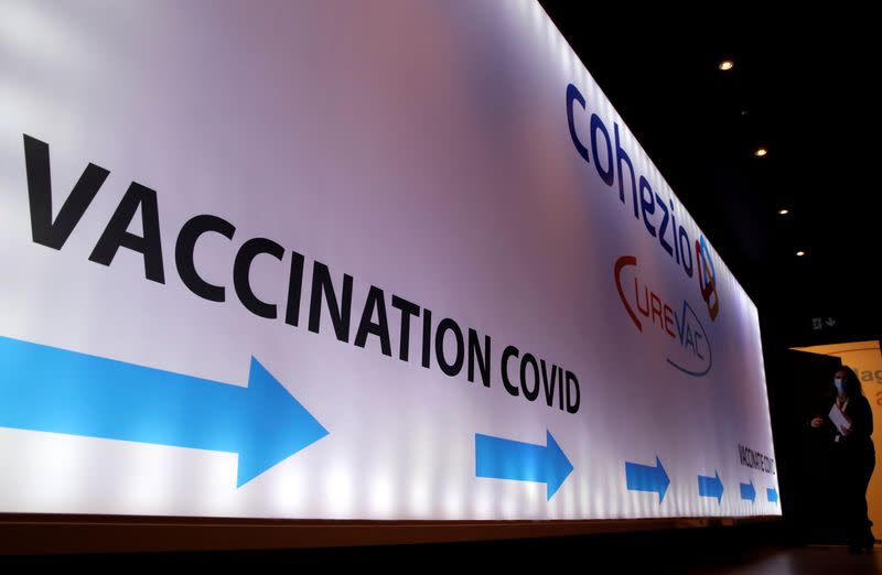 FILE PHOTO: Woman walks past a board in a testing center for the CureVac vaccine during a study in Brussels