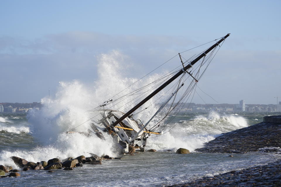 Waves crash against a sailboat in Elsinore, Denmark, Sunday Jan. 30, 2022, after a large winter storm caused havoc in Scandinavia with tens of thousands of people without electricity, trees uprooted and bridges closed. (Keld Navntoft/Ritzau Scanpix via AP)