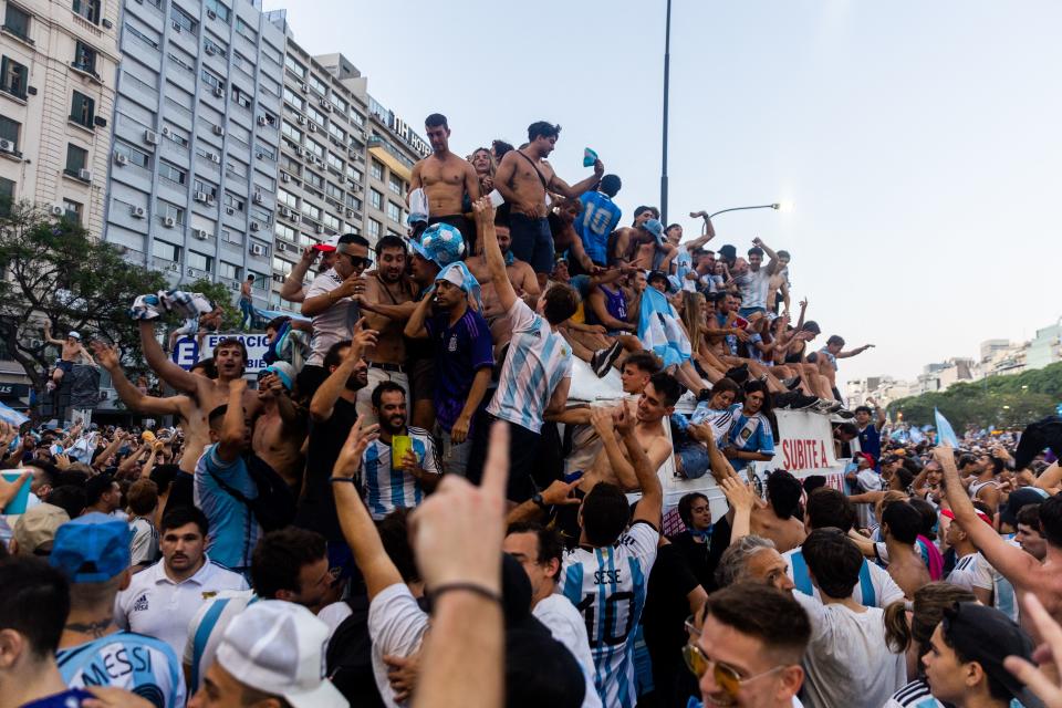 Fans of Argentina celebrate winning the Qatar 2022 World Cup against France at the Obelisk  in Buenos Aires, on December 18, 2022. (Photo by TOMAS CUESTA / AFP) (Photo by TOMAS CUESTA/AFP via Getty Images)