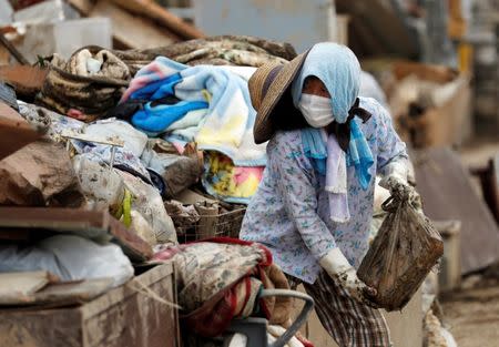 A local resident tries to clear mud and debris at a flood affected area in Mabi town in Kurashiki, Okayama Prefecture, July 13, 2018. REUTERS/Issei Kato