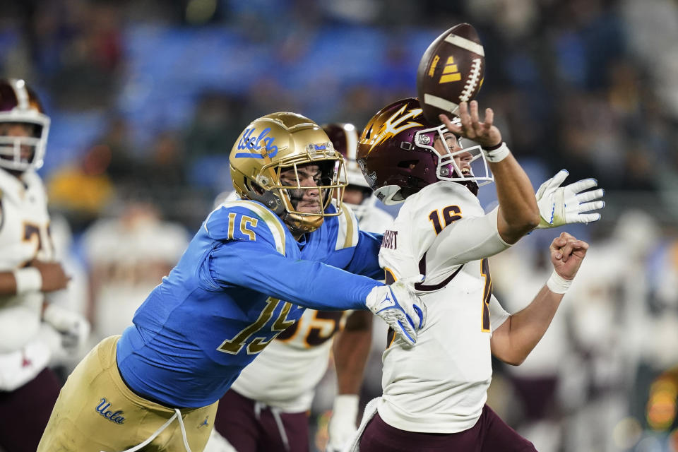 FILE - UCLA defensive lineman Laiatu Latu, left, pressures Arizona State quarterback Trenton Bourguet during the second half of an NCAA college football game Nov. 11, 2023, in Pasadena, Calif. For the final time in its current arrangement, the Morris Trophy winners were honored Thursday, Jan. 18, 2024 — the end to another small chapter of the Pac-12 legacy that crumbled under the weight of conference realignment. The honorees were Washington offensive tackle Troy Fautanu and UCLA's Latu.(AP Photo/Ryan Sun, File)