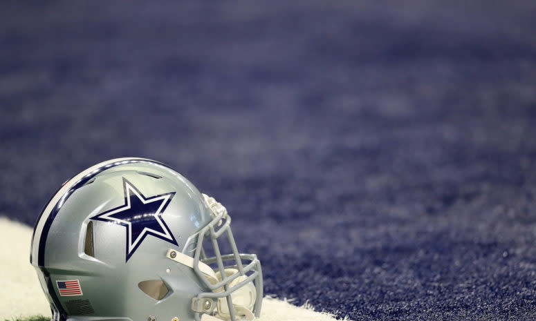 A Dallas Cowboys helmet sitting on the field.