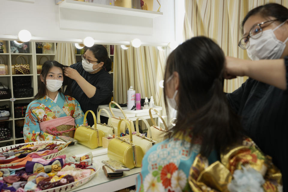 A Japanese woman gets help on her hairdo for her kimono outfit she rented at Daikichi kimono rental shop in the Asakusa area famous for sightseeing, before attending her family friend's wedding in Tokyo, Wednesday, June 22, 2022. Japan is bracing for a return of tourists from abroad, as border controls to curb the spread of coronavirus infections are gradually loosened. Yusuke Otomo, who owns the kimono rental shop, can barely contain his excitement. (AP Photo/Hiro Komae)