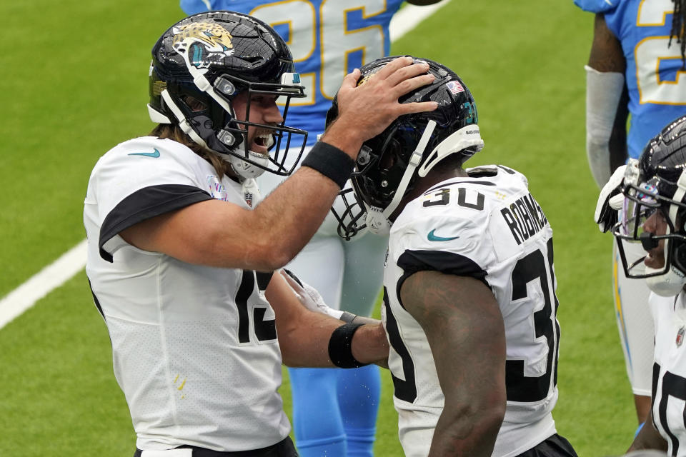 Jacksonville Jaguars running back James Robinson, right, celebrates with Gardner Minshew after lunging into the end zone for a touchdown during the first half of an NFL football game against the Los Angeles Chargers Sunday, Oct. 25, 2020, in Inglewood, Calif. (AP Photo/Alex Gallardo )