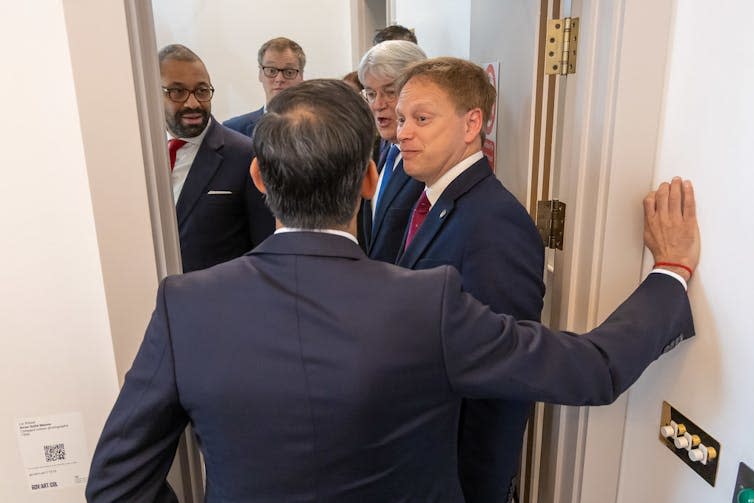 The back of Rishi Sunak's head as he speaks to cabinet ministers in a doorway.