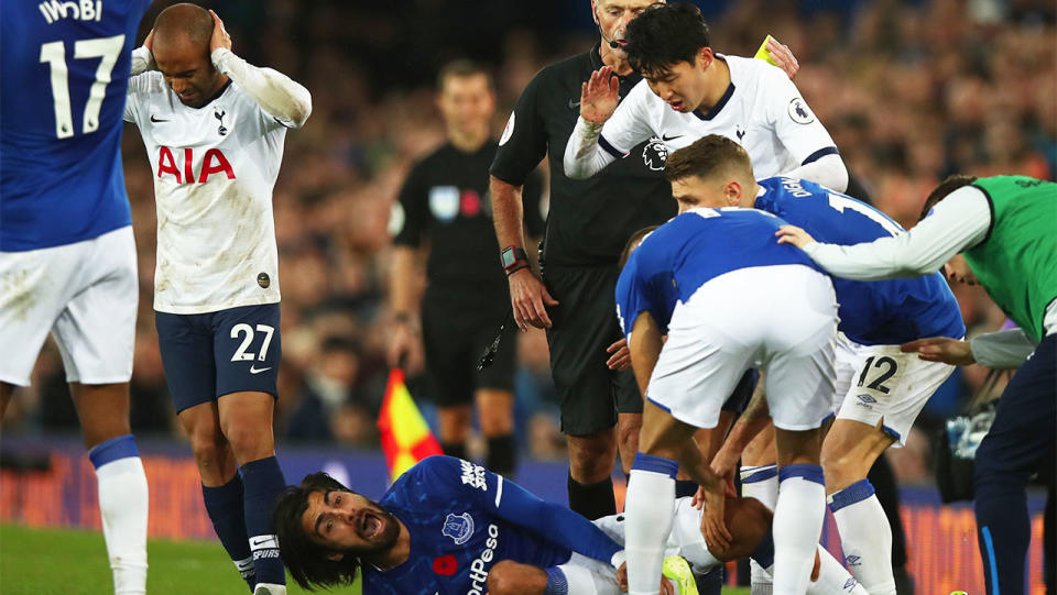 Son Heung-min looks on in horror with other players as Andre Gomes screams in pain after a tackle.