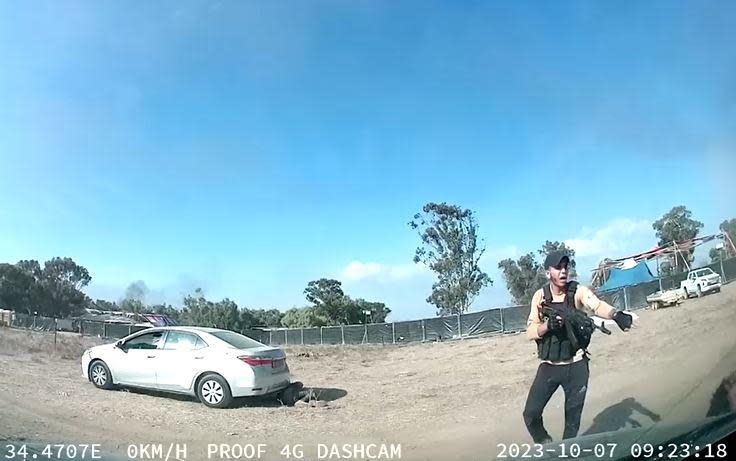 A screengrab taken from a car's dashcam video shows a Hamas militant firing a rifle at people who were attending the Supernova music festival near Re'im, in the southern Israeli desert, just a couple miles from the border with the   Gaza Strip Palestinian territory, Oct. 7, 2023.  / Credit: Obtained by Reuters