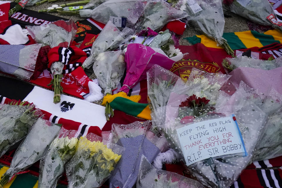 Tributes in memory of Sir Bobby Charlton are laid outside the stadium, following his death prior the Champions League group A soccer match between Manchester United and Copenhagen at the Old Trafford stadium in Manchester, England, Tuesday, Oct. 24, 2023. Manchester United and England soccer great Bobby Charlton has died at the age of 86. He was an English soccer icon who survived a plane crash that decimated a United team destined for greatness to become the heartbeat of his country's 1966 World Cup-winning team. (AP Photo/Dave Thompson)