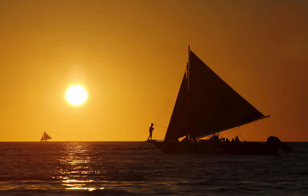 FILE PHOTO: Tourists catch a glimpse of the sunset while sailing along the island of Boracay, central Philippines January 17, 2016. REUTERS/Charlie Saceda/File Photo