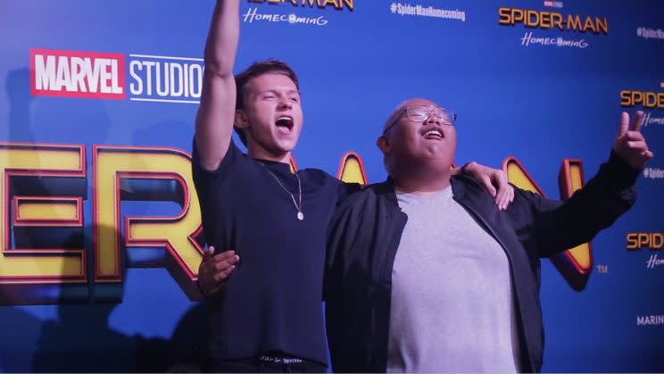 Tom Holland and Jacob Batalon cheering on stage.