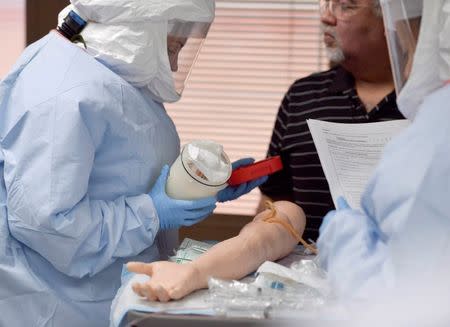 Participants practise a medical procedure on a dummy arm during training for the Ebola response team at Fort Sam Houston in San Antonio, Texas October 24, 2014. REUTERS/Darren Abate